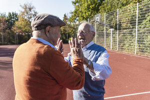 Zwei fitte Senioren, die sich auf einem Basketballfeld die Hände reichen - UUF15552