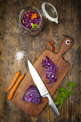 Homemade red cabbage, fermented, with chili, carrot and coriander, preserving jar on wood - LVF07485