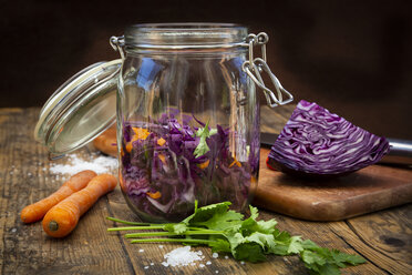 Hausgemachter Rotkohl, fermentiert, mit Chili, Karotte und Koriander, Einmachglas auf Holz - LVF07487