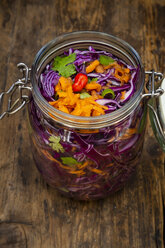 Homemade red cabbage, fermented, with chili, carrot and coriander, preserving jar on wood - LVF07488