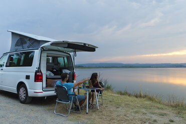 Pärchen beim Abendessen im Wohnmobil bei Sonnenuntergang auf dem See - SKCF00541