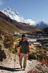 Männlicher Wanderer mit Wanderstock auf einem Berg vor blauem Himmel im Sagarmatha-Nationalpark - CAVF49980