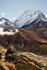 Rückansicht eines männlichen Wanderers, der auf einem Felsen gegen den blauen Himmel im Sagarmatha-Nationalpark steht, an einem sonnigen Tag - CAVF49981