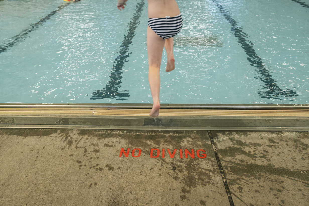 Low section of girl wearing striped underwear while diving into