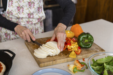 Midsection of woman cutting cheese while preparing food in kitchen at home - CAVF50081