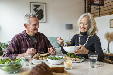 Lächelndes Paar beim Mittagessen am Esstisch - CAVF50086