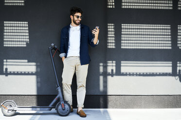 Smiling young man with electric scooter taking selfie with smartphone - BSZF00762