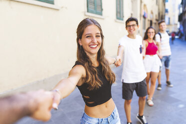 Group of friends walking and holding hands in the city - WPEF00936