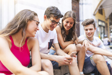 Eine Gruppe von Freunden teilt sich ein Handy in der Stadt - WPEF00946