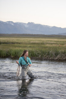 Junge Frau beim Fliegenfischen im Owens River vor dem Hintergrund der Berge - CAVF50118