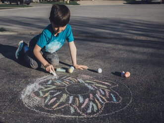 Boy drawing with chalk on asphalt - CAVF50124