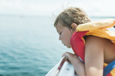 Seitenansicht eines Mädchens mit Schwimmweste, das in einem Boot auf einem See sitzt - CAVF50175