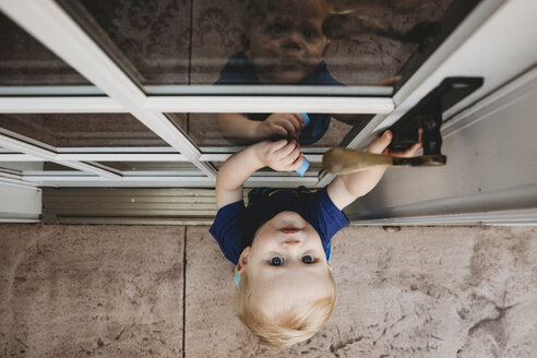 Hohe Winkel Porträt der niedlichen Baby Junge Öffnen der Tür - CAVF50229