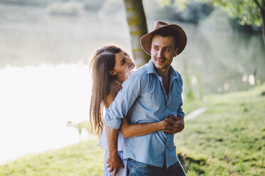 Romantic couple embracing while standing at park - CAVF50246