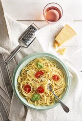 High angle view of spaghetti served in plate with drink and cheese on table - CAVF50303