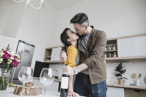 Verliebtes Paar beim Küssen in der Küche, lizenzfreies Stockfoto