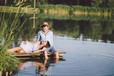 Freundin liegt auf dem Schoß ihres Freundes am See im Park - CAVF50313