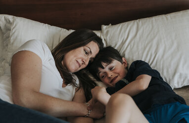 Mutter und Sohn liegen zu Hause auf dem Bett - CAVF50340
