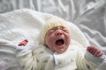 Overhead-Ansicht von niedlichen neugeborenen Baby Mädchen weinen, während auf dem Bett zu Hause liegen - CAVF50380