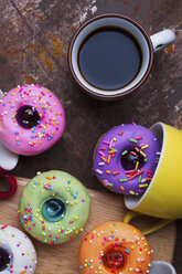 Hohe Winkel Ansicht der bunten Donuts mit Kaffee auf Holztisch - CAVF50392