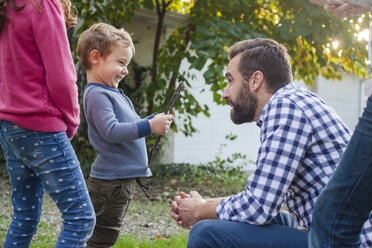 Father playing with children in yard - CAVF50432