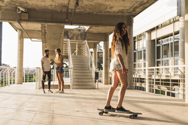 Freunde mit Skateboard beim Entspannen in der Stadt - KKAF02480