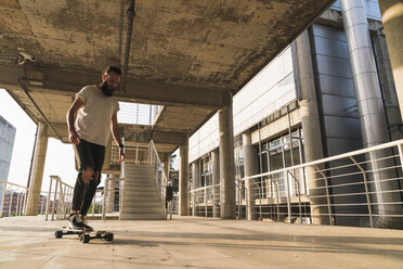 Young man riding skateboard in the city - KKAF02483