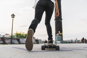 Nahaufnahme einer jungen Frau beim Skateboardfahren in der Stadt - KKAF02519