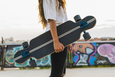 Junge Frau mit Skateboard in der Stadt - KKAF02521