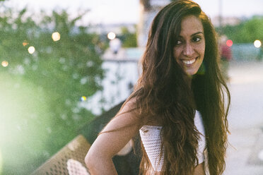 Portrait of beautiful smiling young woman with long brown hair outdoors - KKAF02530