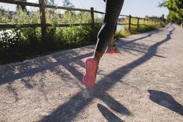 Legs of sportive woman running on path - FMOF00385