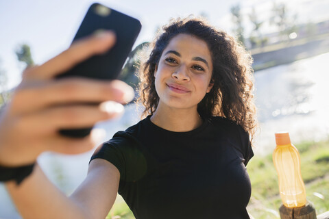 Sportive young woman taking a selfie at the riverside stock photo
