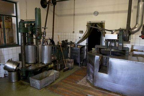Hydraulische Presse und Rührwerkskessel in einer Ölmühle, lizenzfreies Stockfoto