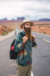 USA, Utah, Mann mit Rucksack auf dem Weg zum Monument Valley - KKAF02537