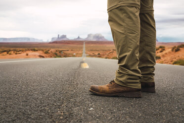 USA, Utah, Man standing on road to Monument Valley - KKAF02539