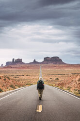 USA, Utah, Mann mit Rucksack auf dem Weg zum Monument Valley - KKAF02540