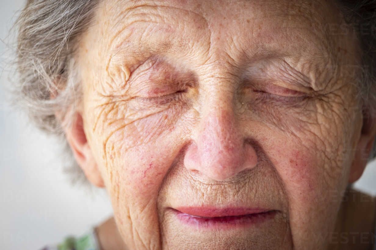 Close up of sad senior woman with eyes closed stock photo