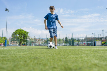 Niedriger Blickwinkel des Jungen üben Fußball auf dem Feld gegen den Himmel - CAVF50550