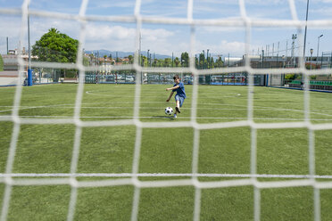 Junge kickt Fußball gegen den Himmel durch das Netz gesehen - CAVF50552
