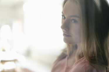 Portrait of daydreaming young woman behind glass pane - KNSF05004