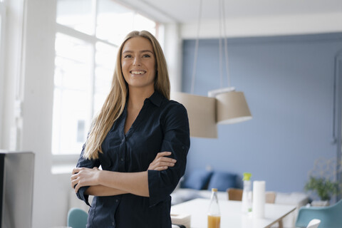 Porträt einer lächelnden jungen Geschäftsfrau im Büro, lizenzfreies Stockfoto