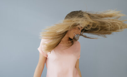 Lachende junge Frau, die ihr Haar wirft - KNSF05015