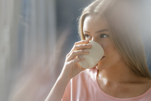 Junge Frau trinkt eine Tasse Kaffee - KNSF05021