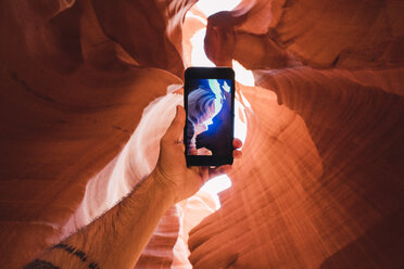 USA, Arizona, tourist in Lower Antelope Canyon, photo on smartphone - KKAF02555