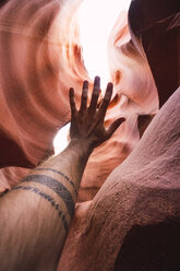 USA, Arizona, Tourist im Lower Antelope Canyon, erhobener Arm, Tätowierung - KKAF02560