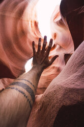 USA, Arizona, tourist in Lower Antelope Canyon, raised arm, tattoo - KKAF02560