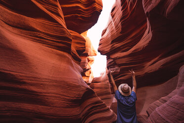 USA, Arizona, Tourist macht Siegeszeichen im Lower Antelope Canyon - KKAF02576