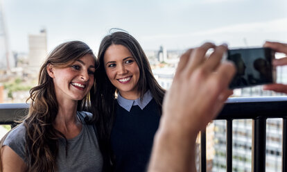 UK, London, Freunde fotografieren mit Blick auf die Stadt - MGOF03804