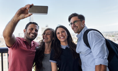 Großbritannien, London, vier Freunde machen ein Selfie mit der Stadt im Hintergrund - MGOF03805