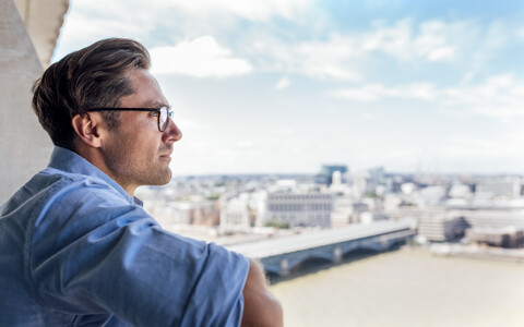 UK, London, man looking at the city on a roof terrace stock photo